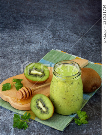 green smoothies from kiwi, oatmeal, nuts and honey on dark background. green smoothies from kiwi, oatmeal, nuts and honey on dark background. 128531734