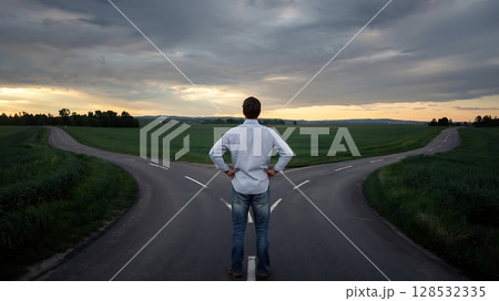 Person standing at an intersection with choices marked on road. Person standing at an intersection with choices marked on road. 128532335