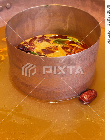 Closeup of a fresh hot pot broth, ready to be boiled and to add in food ingredient. Closeup of a fresh hot pot broth, ready to be boiled and to add in food ingredient. 128532938