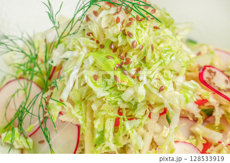 Fresh cabbage salad with sliced radishes, flax seeds, and dill, offering a light and crunchy texture perfect for a healthy meal Fresh cabbage salad with sliced radishes, flax seeds, and dill, offering a light and crunchy texture perfect for a healthy meal 128533919