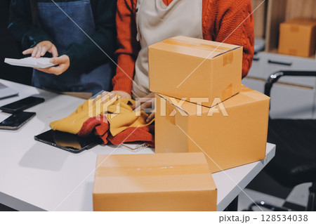 Portrait of Starting small businesses SME owners, two Asian woman check online orders Selling products working with boxs freelance work at home office, sme business online small medium enterprise 128534038