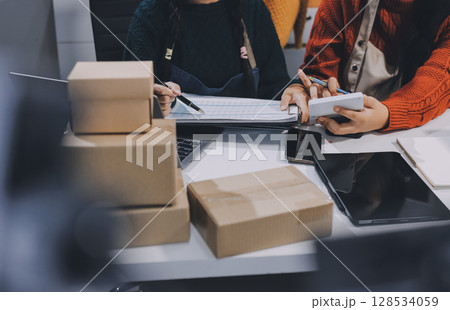 Portrait of Starting small businesses SME owners, two Asian woman check online orders Selling products working with boxs freelance work at home office, sme business online small medium enterprise 128534059