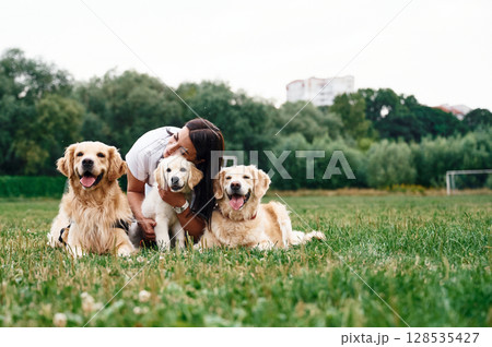 Woman with beautiful dogs are in the field outdoors Woman with beautiful dogs are in the field outdoors 128535427