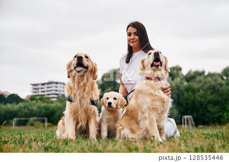 Front view. Woman with beautiful dogs are in the field outdoors 128535446