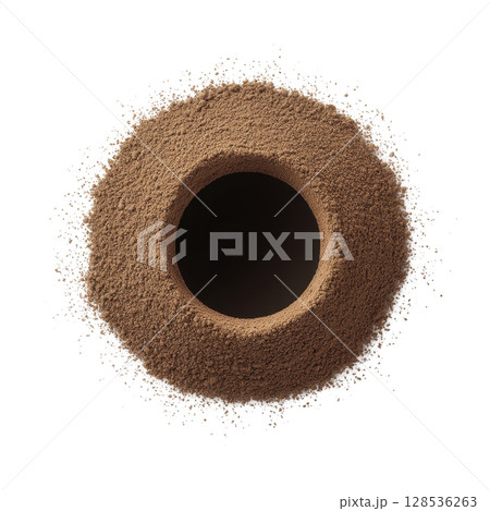 Circular mound of brown powder is surrounded by scattered dusting, creating textured and dynamic visual. central void adds depth and contrast to composition 128536263