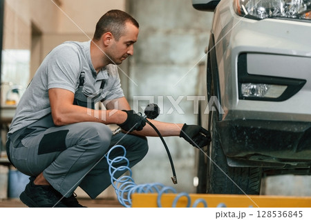 Man is works in the automobile repairing salon Man is works in the automobile repairing salon 128536845