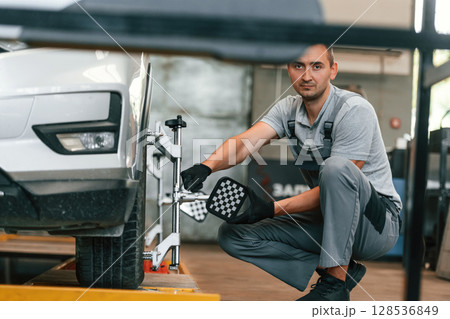 Wheel changing. Man is works in the automobile repairing salon Wheel changing. Man is works in the automobile repairing salon 128536849