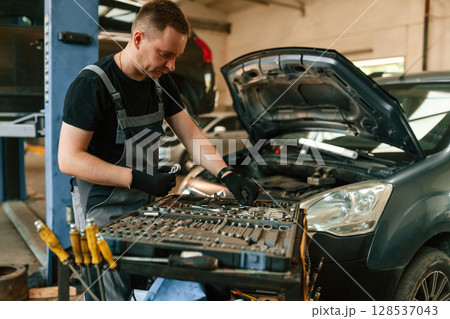 Under the hood. Man is works in the automobile repairing salon 128537043