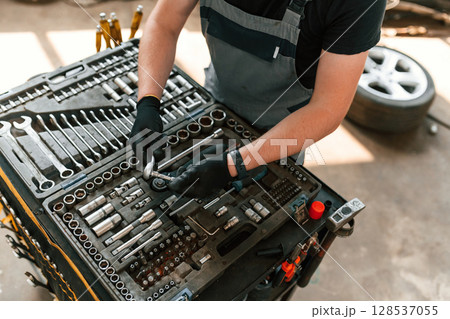 Standing by the toolbox. Man is works in the automobile repairing salon 128537055