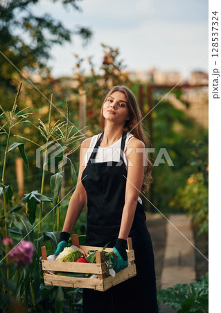 Black and white clothes, uniform for work. Beautiful young woman is gardening 128537324