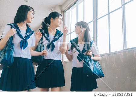 学校の廊下を歩く女子高生3人組 128537351