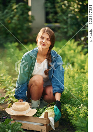 Smiling and sitting. Beautiful young woman is gardening 128537381