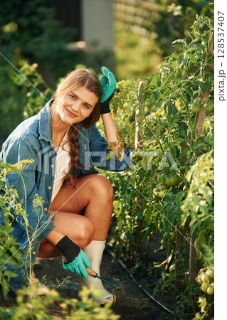 Tired, sitting and resting. Beautiful young woman is gardening Tired, sitting and resting. Beautiful young woman is gardening 128537407