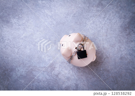 Closed piggy bank. Locked savings. Money protection concept. 128538292