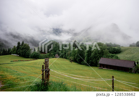 Misty mountain valley with green pastures in the Austrian Alps Misty mountain valley with green pastures in the Austrian Alps 128538662