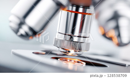 Close-up view of a microscope lens focusing on a glass slide, showcasing intricate details and precision in scientific research and analysis Close-up view of a microscope lens focusing on a glass slide, showcasing intricate details and precision in scientific research and analysis 128538709