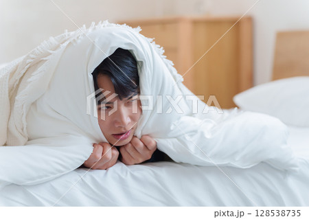 布団に篭もる男性 布団に篭もる男性 128538735