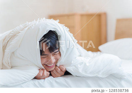 布団に篭もる男性 布団に篭もる男性 128538736