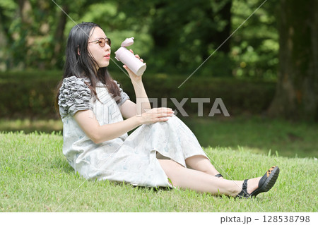 水筒を持って休憩する若い女性 128538798