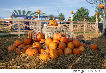 Pile of pumpkins and hay in festive Halloween setup 128538938