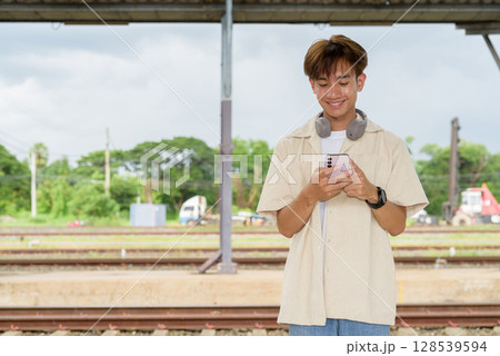 Young non binary tourist traveler in train station Young non binary tourist traveler in train station 128539594