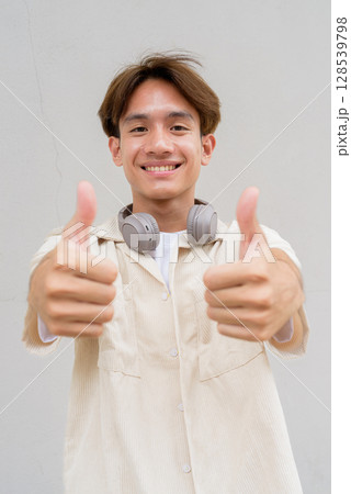 Non binary person giving thumbs up and smiling Non binary person giving thumbs up and smiling 128539798
