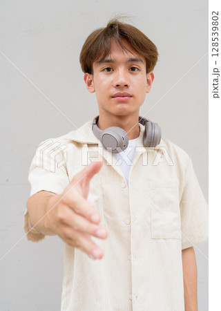 Non binary cute Asian young gay man giving handshake and greeting 128539802