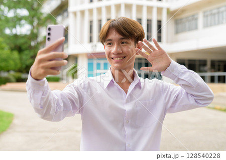 University student using phone in campus taking selfie University student using phone in campus taking selfie 128540228
