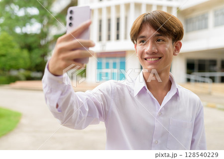 University student using phone in campus taking selfie University student using phone in campus taking selfie 128540229