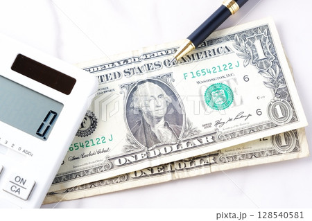 1ドル紙幣 - 初代大統領「ジョージ・ワシントン」のアメリカ合衆国ドル（US＄）1ドル紙幣と白い電卓 128540581