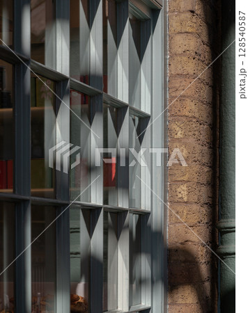 Sunlight streams through bakery shop glass window display. 128540587