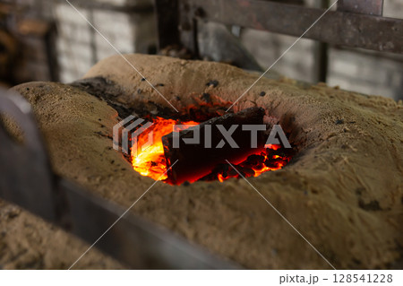 Ferrous metal billet is melted in an induction furnace closeup Ferrous metal billet is melted in an induction furnace closeup 128541228