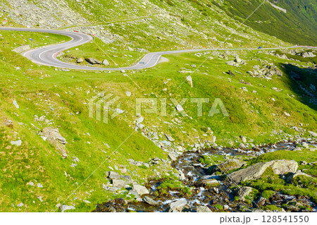 landscape with transfagarasan road in summer. travel romania. scenic view of valley with steep rocky hills and water stream on a sunny morning. alpine scenery of transylvania 128541550