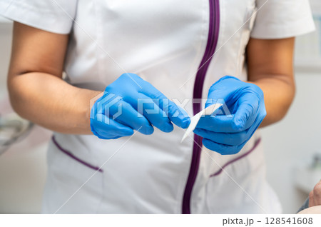 Nurse preparing gauze to treat a patient Nurse preparing gauze to treat a patient 128541608