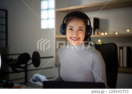 Smiling Podcast Host in Home Studio with Notes Smiling Podcast Host in Home Studio with Notes 128541753