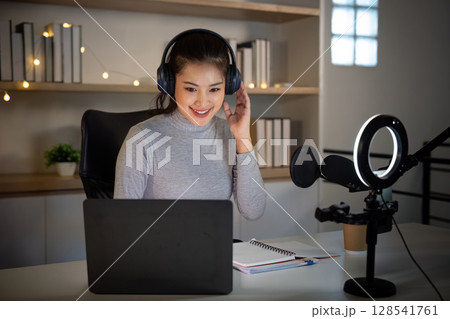 Podcast Host Engaging with Audience in Home Studio Podcast Host Engaging with Audience in Home Studio 128541761