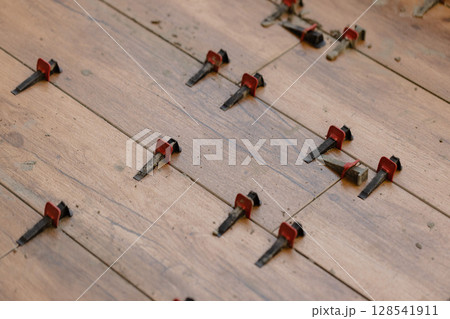 Tile Leveling System Components on The Floor. Closeup, selective focus. 128541911