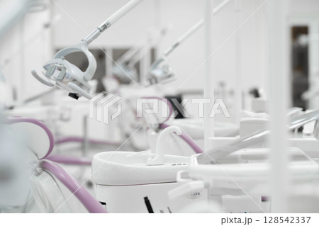 A plastic glass on a cup holder of the modern ceramic mouth cleaning sink in the dentist office near a window, A plastic glass on a cup holder of the modern ceramic mouth cleaning sink in the dentist office near a window, 128542337