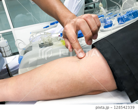 Blood platelet donation, a male nurse inserts a needle into donor arm to draw blood at a hospital. Blood platelet donation, a male nurse inserts a needle into donor arm to draw blood at a hospital. 128542339