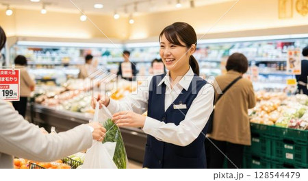 お客様の代わりに野菜を袋詰めするスーパーの女性店員 128544479