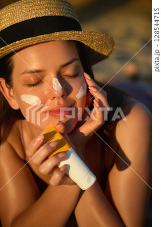 Woman is applying a facial sunscreen product. Cream, moisturizer and facial woman in skincare, beauty or cosmetics. Face daily care routine. Woman is applying a facial sunscreen product. Cream, moisturizer and facial woman in skincare, beauty or cosmetics. Face daily care routine. 128544715