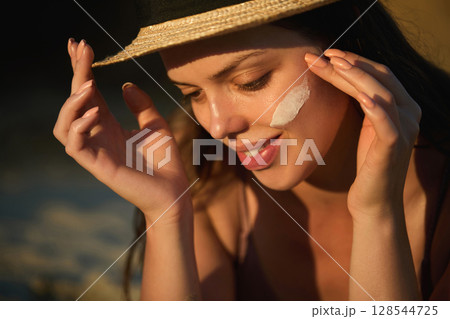 Beautiful Woman Applying Suntan Lotion, Sunscreen Solar Cream on Face. Portrait Beauty Skin Care Concept.Sun protection. A Girl Uses Moisturizer Sunblock 128544725