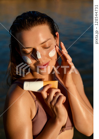 Beauty woman with suntan spf and skincare cosmetics model face portrait, woman applying lotion cream, sunscreen product. Skin and body care. A female smears moisturizing or suntan.Sun protection Beauty woman with suntan spf and skincare cosmetics model face portrait, woman applying lotion cream, sunscreen product. Skin and body care. A female smears moisturizing or suntan.Sun protection 128544731