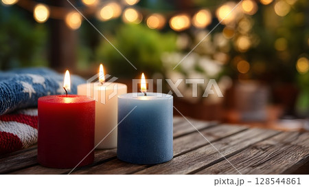 Three candles in red, white, and blue colors on a wooden table. Soft bokeh lights in the background create a festive atmosphere. Suitable for USA holidays. Three candles in red, white, and blue colors on a wooden table. Soft bokeh lights in the background create a festive atmosphere. Suitable for USA holidays. 128544861
