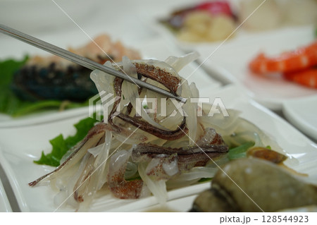 Close-up of Freshly Sliced Raw Squid Served as Side Dish in Korean Seafood Restaurant 128544923