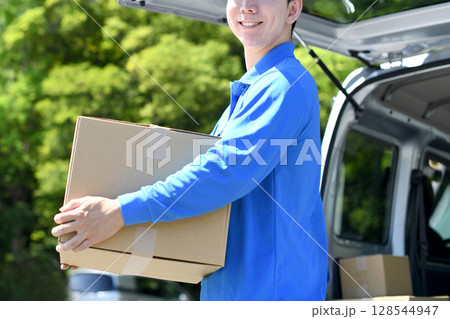 荷物を運ぶアジア人の男性の配達スタッフ 128544947