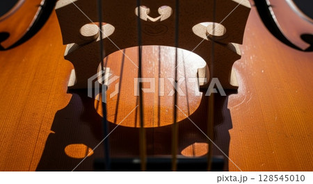 Detailed Macro Shot of Violin Soundhole with Wooden Grain Texture and Shadows 128545010