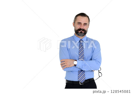 Portrait of confident middle-aged businessman in blue shirt and holding glasses with a beard and mustache standing on white background with copy space. Portrait of confident middle-aged businessman in blue shirt and holding glasses with a beard and mustache standing on white background with copy space. 128545081