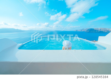 ギリシャのサントリーニ島のプールで泳ぐ女性 128545164