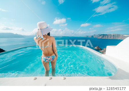 ギリシャのサントリーニ島のプールで泳ぐ女性 ギリシャのサントリーニ島のプールで泳ぐ女性 128545177